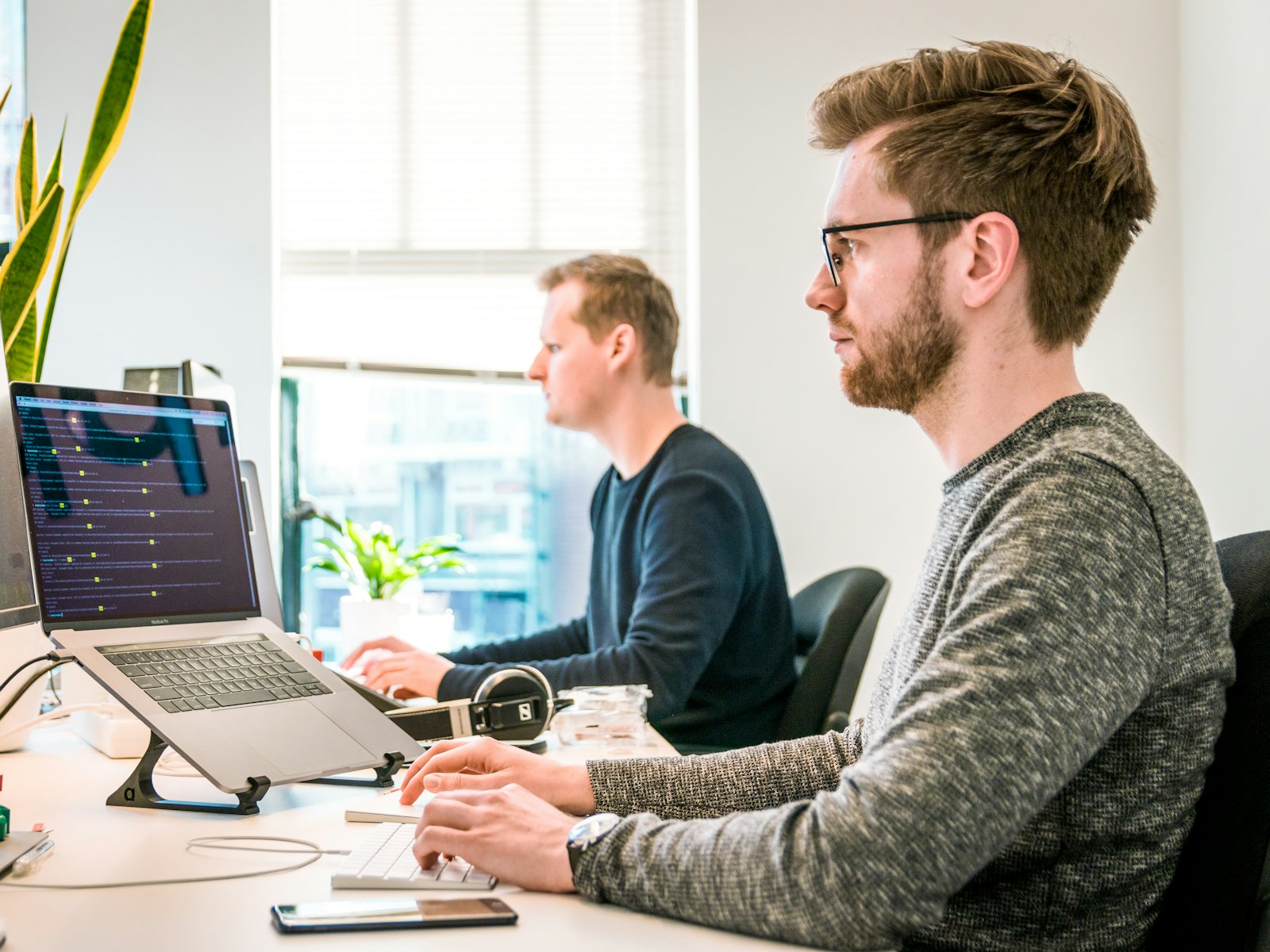 Two developers working at their desks in a bright office
